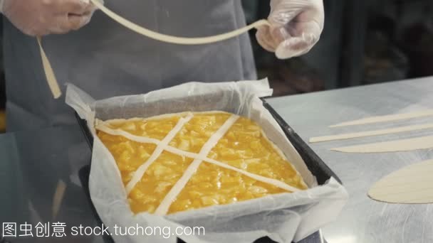 人準備水果橙色檸檬餡餅在廚房桌上, 最后的裝飾在手套, 餐廳廚房烘焙產品工廠